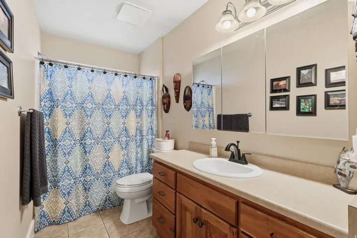 Bathroom featuring vanity, curtained shower, and light tile patterned flooring
