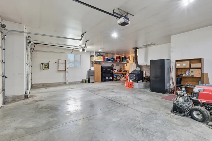 Garage featuring freestanding refrigerator and a garage door opener