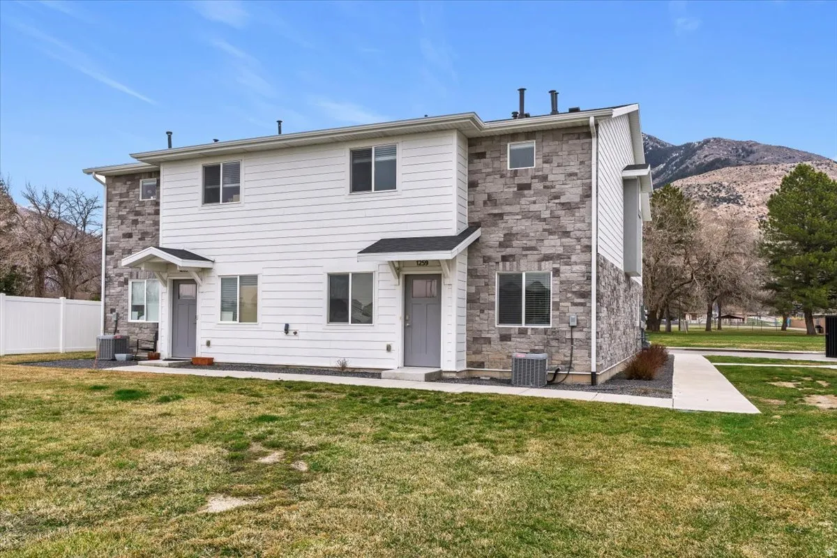 Rear view of property featuring stone siding and a mountain view