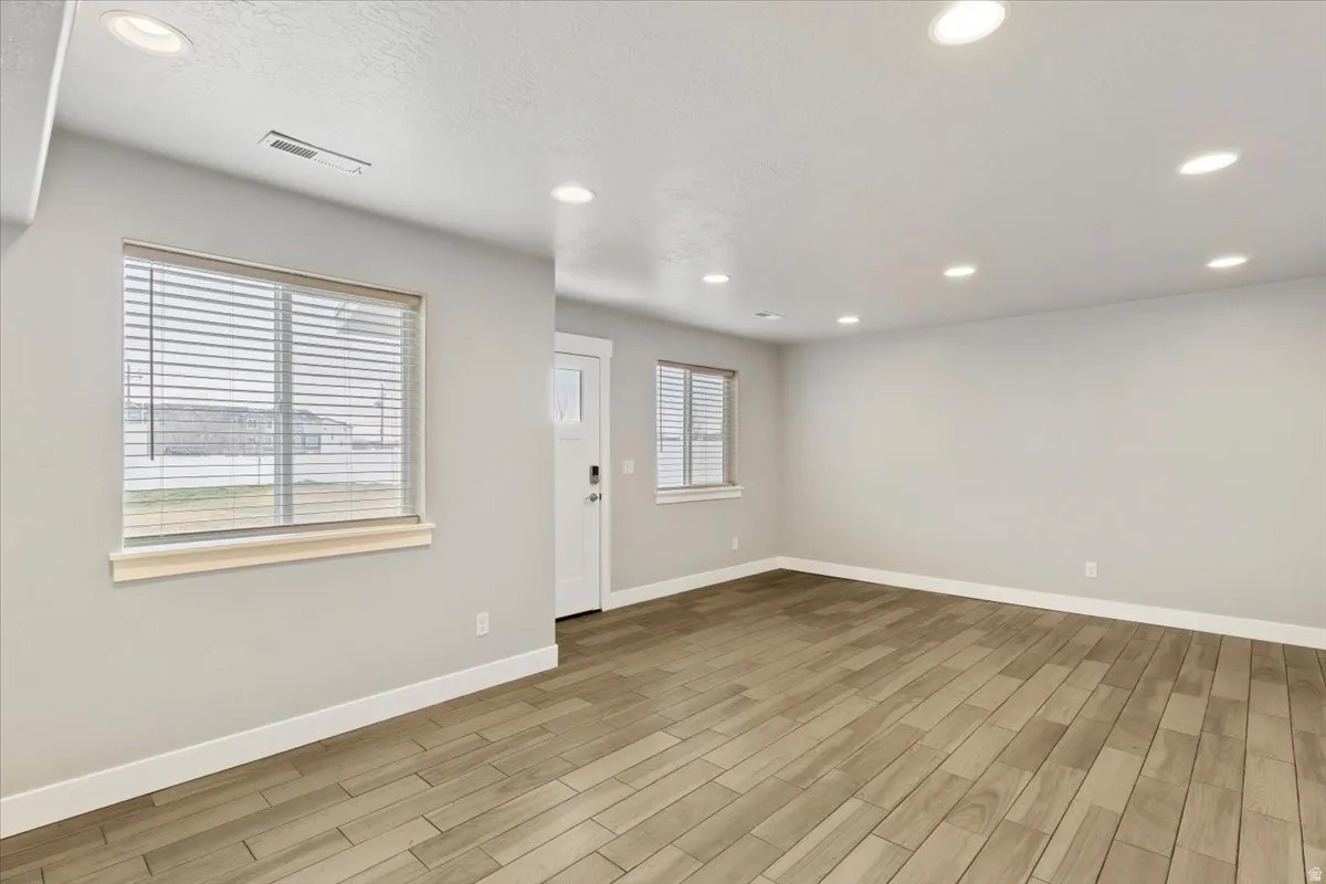 Unfurnished room with wood tiled floors and recessed lighting