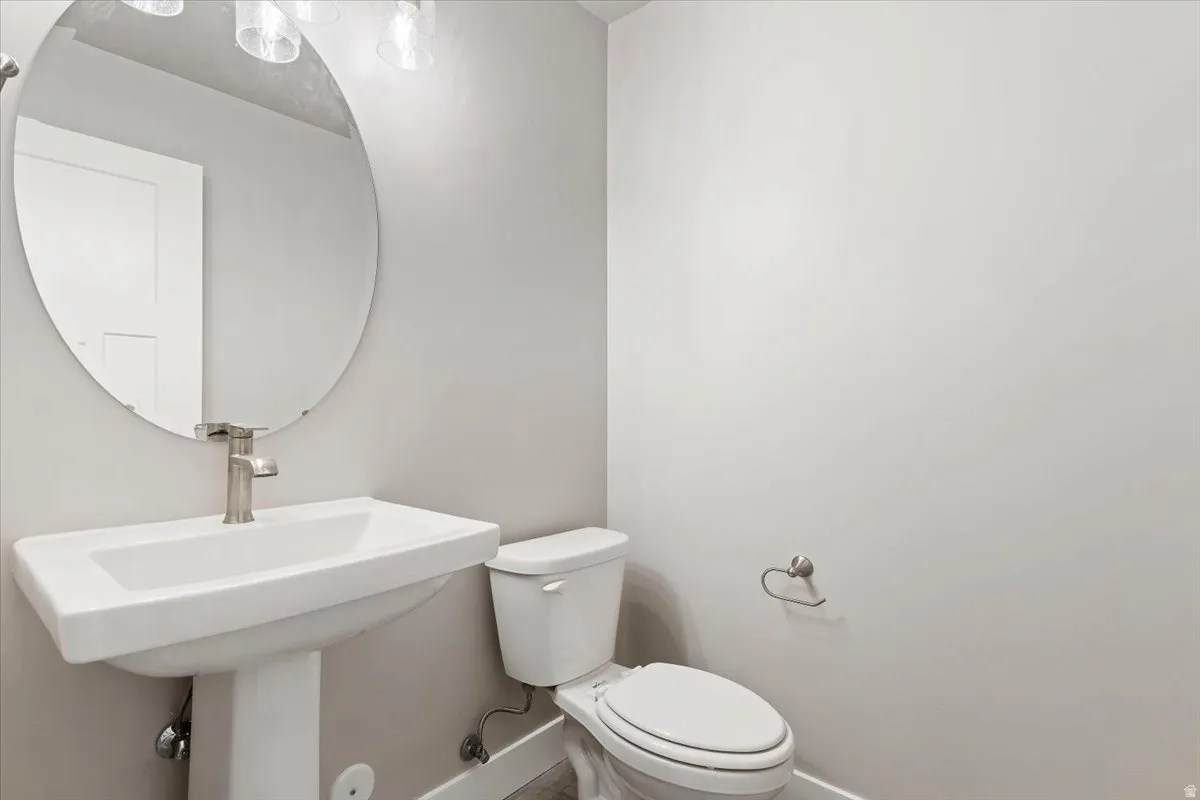 Half bathroom with toilet and baseboards