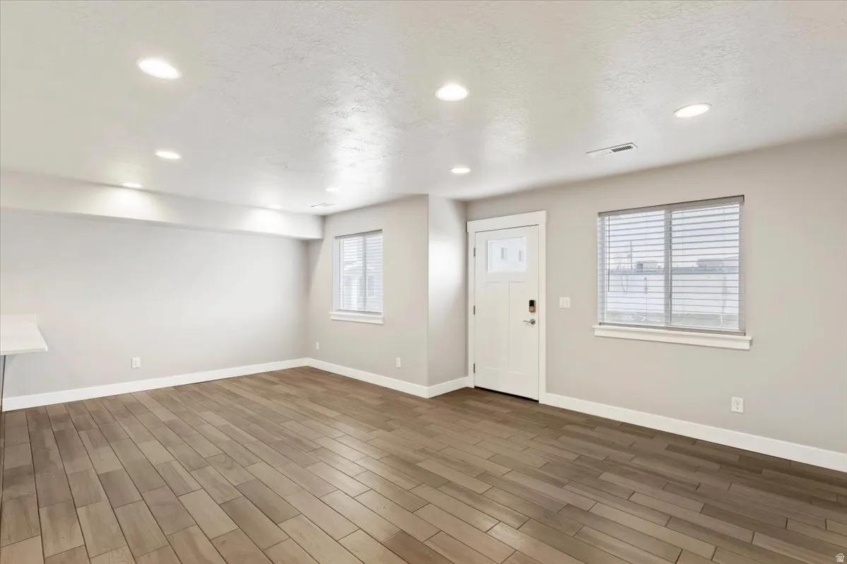 Entrance foyer featuring wood finish floors, a textured ceiling, recessed lighting, and plenty of natural light