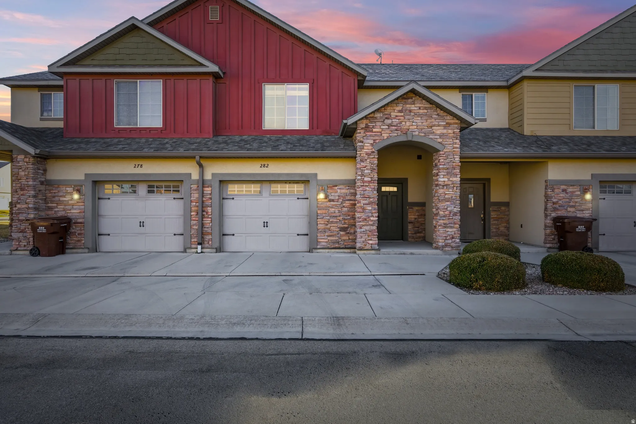 Craftsman-style house with an attached garage, driveway, board and batten siding, and stucco siding
