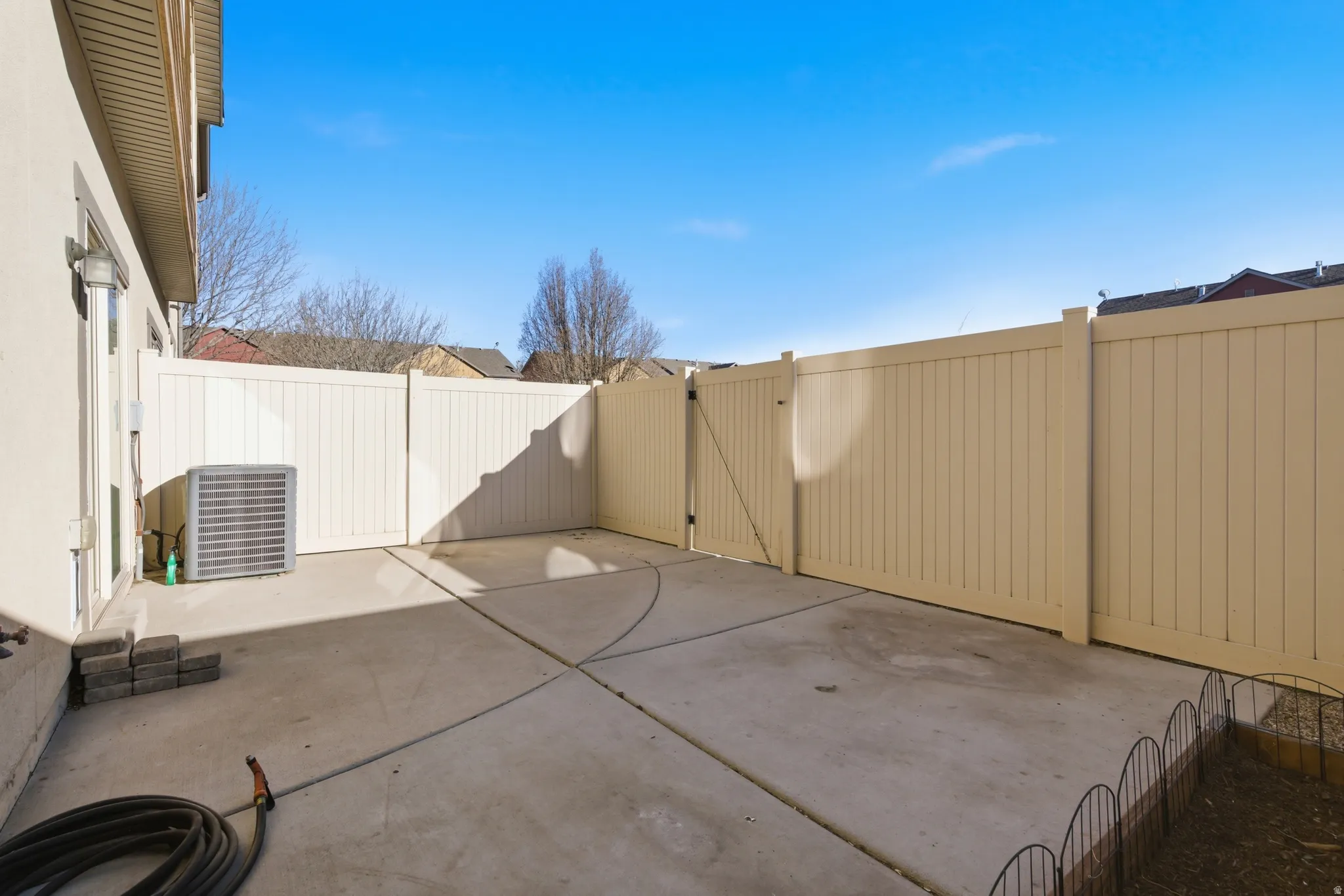 Fenced backyard with a gate and a patio
