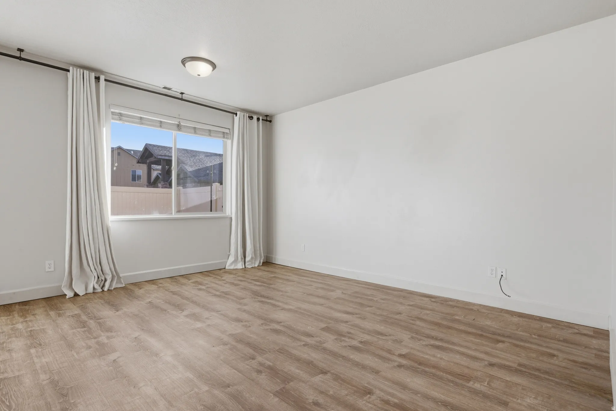 Unfurnished room featuring light wood-style flooring and baseboards