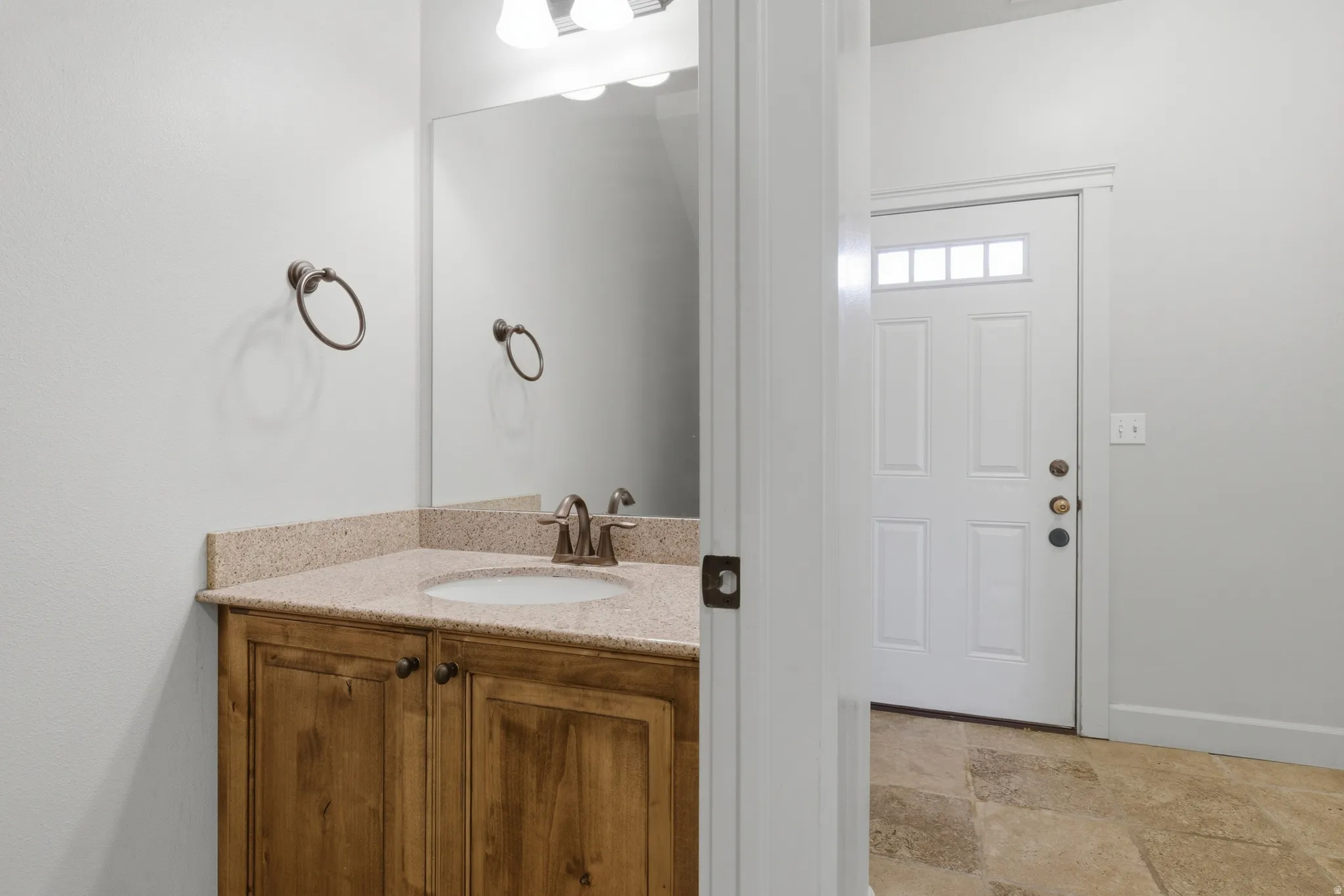 Bathroom featuring vanity and light stone finish flooring