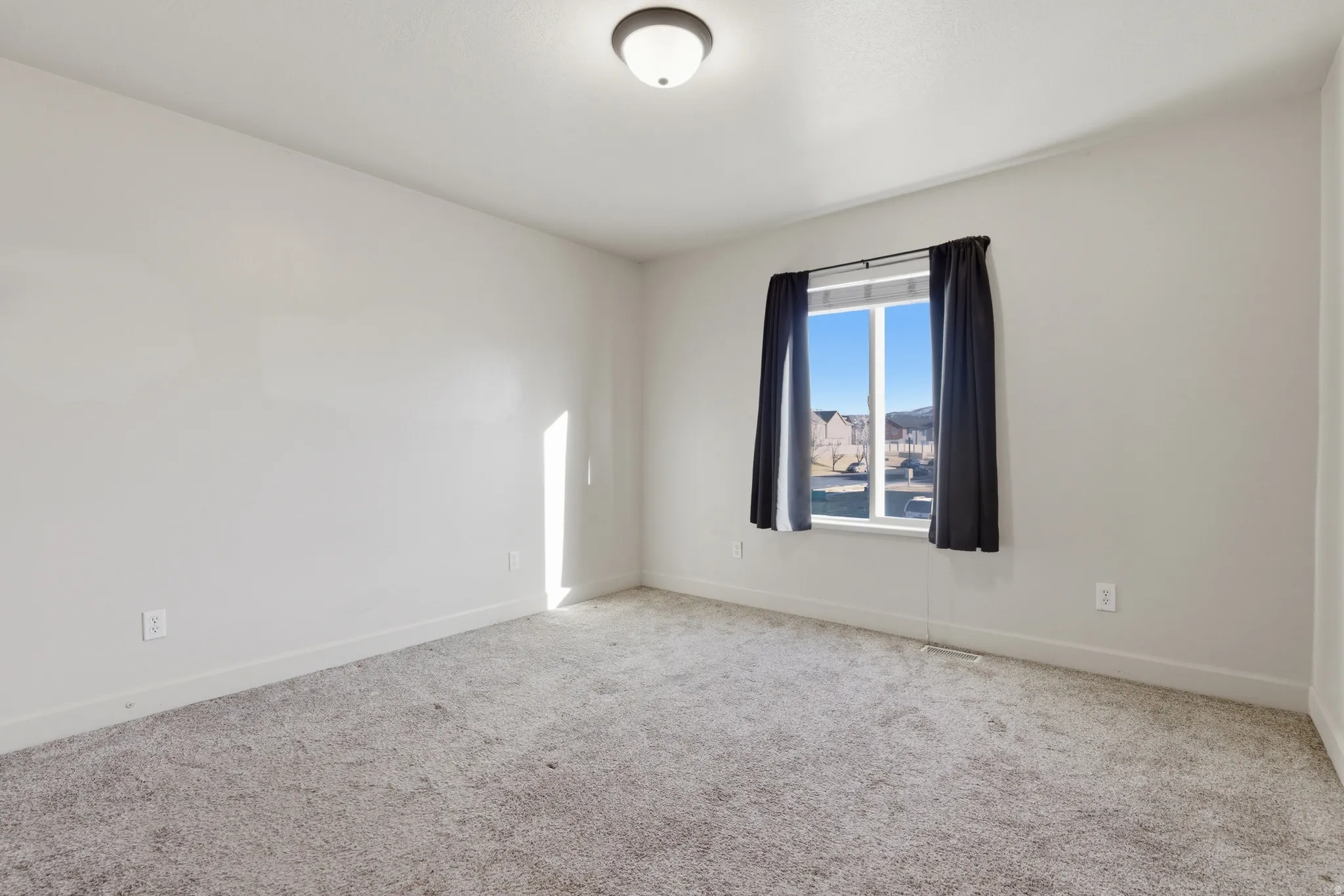 Carpeted empty room featuring baseboards