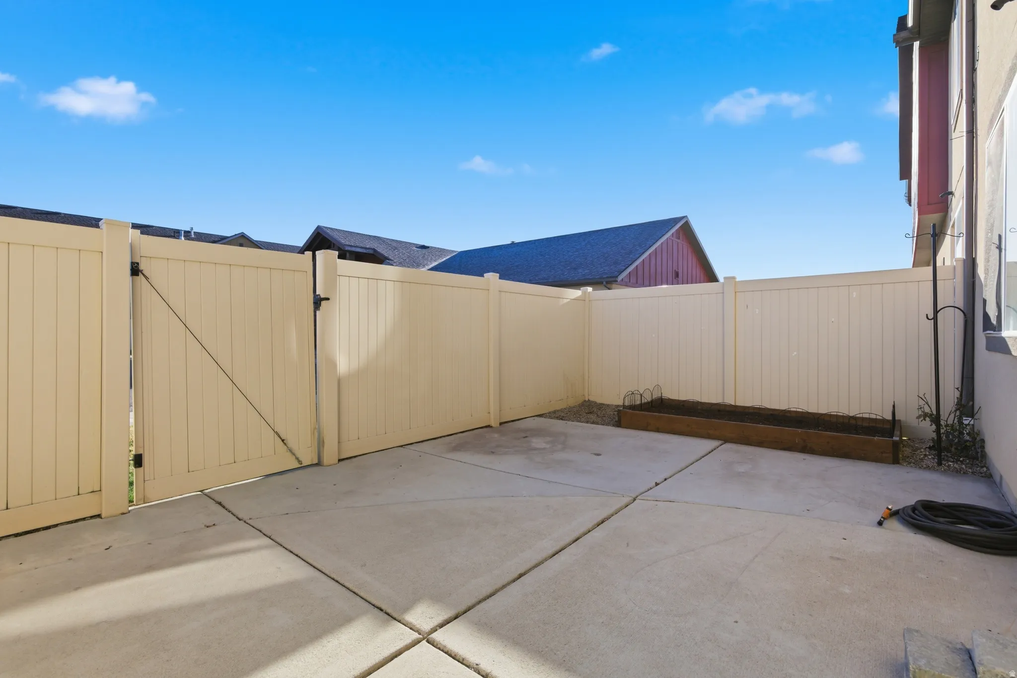 Fenced backyard featuring a patio and a gate