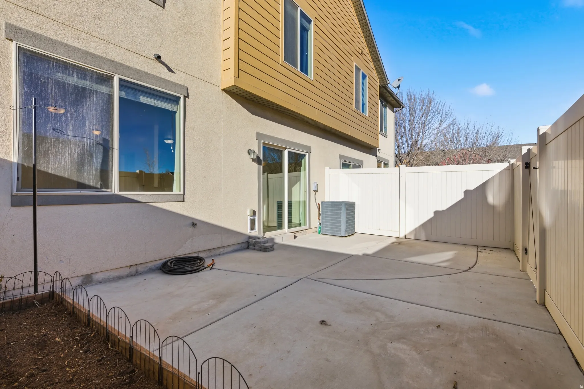 Back of property with a fenced backyard, a patio area, and stucco siding
