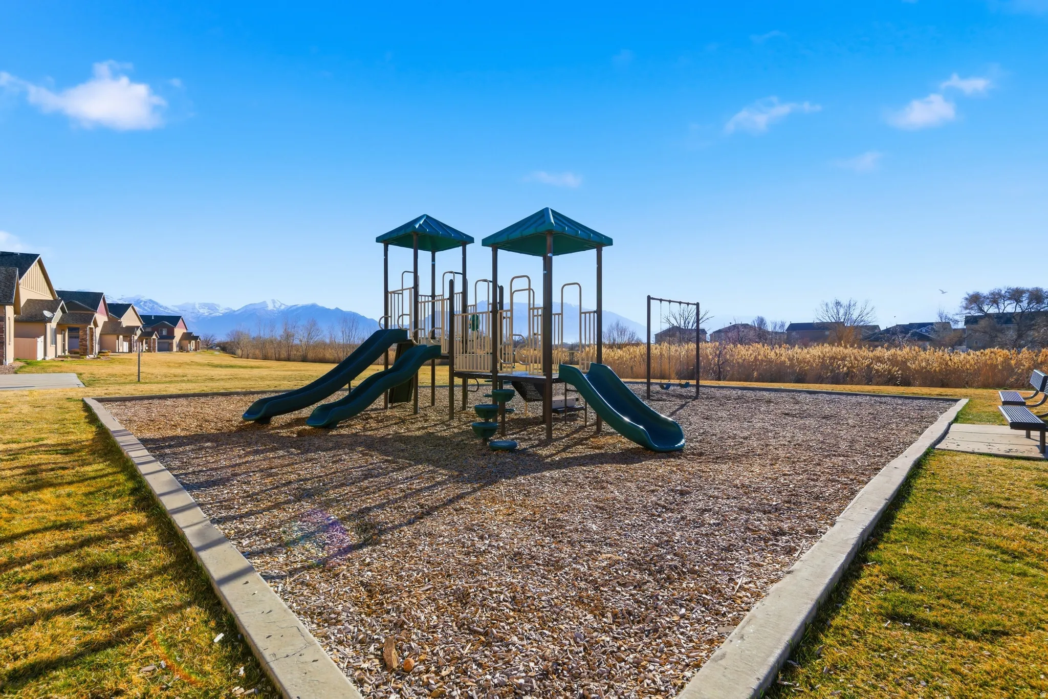 Community jungle gym with a lawn and a mountain view