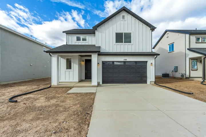 Modern farmhouse featuring board and batten siding, an attached garage, driveway, covered porch, and a shingled roof