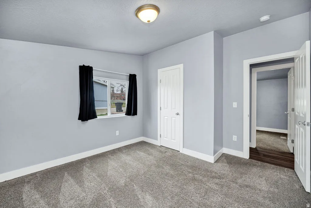 Unfurnished bedroom with carpet floors, a closet, and a textured ceiling