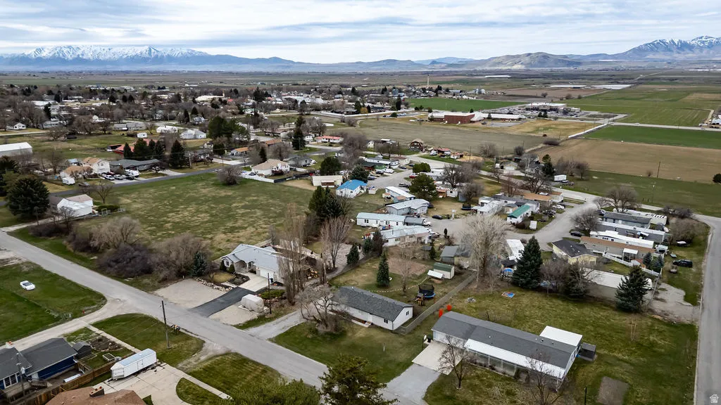 Aerial view of property and surrounding area featuring nearby suburban area and mountains