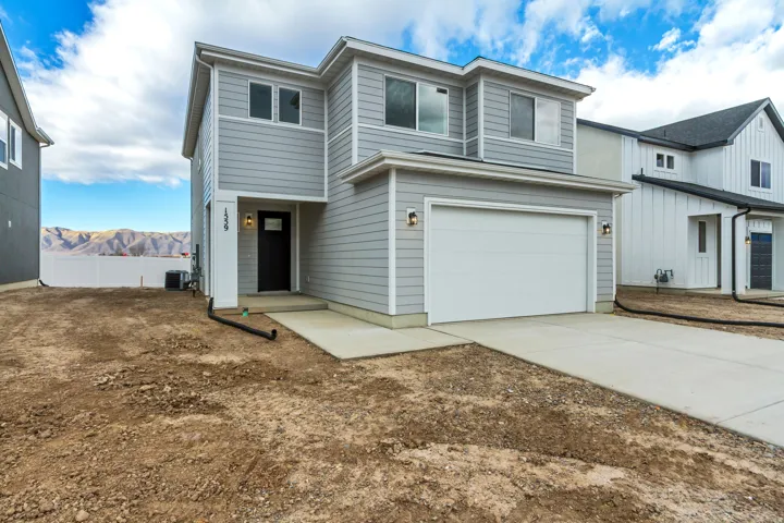 View of front facade with an attached garage, concrete driveway, and a mountain view