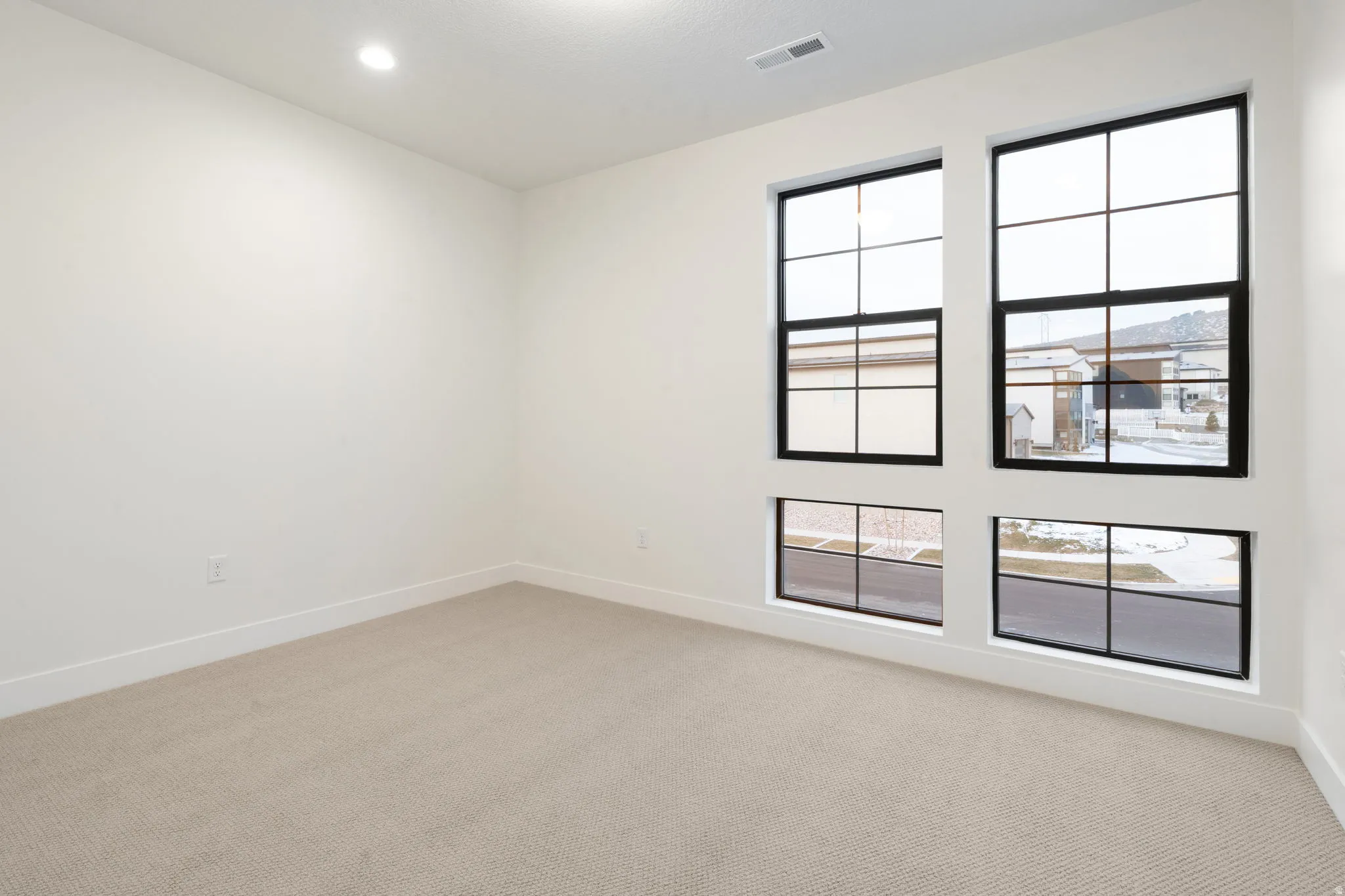 Empty room with light carpet and baseboards