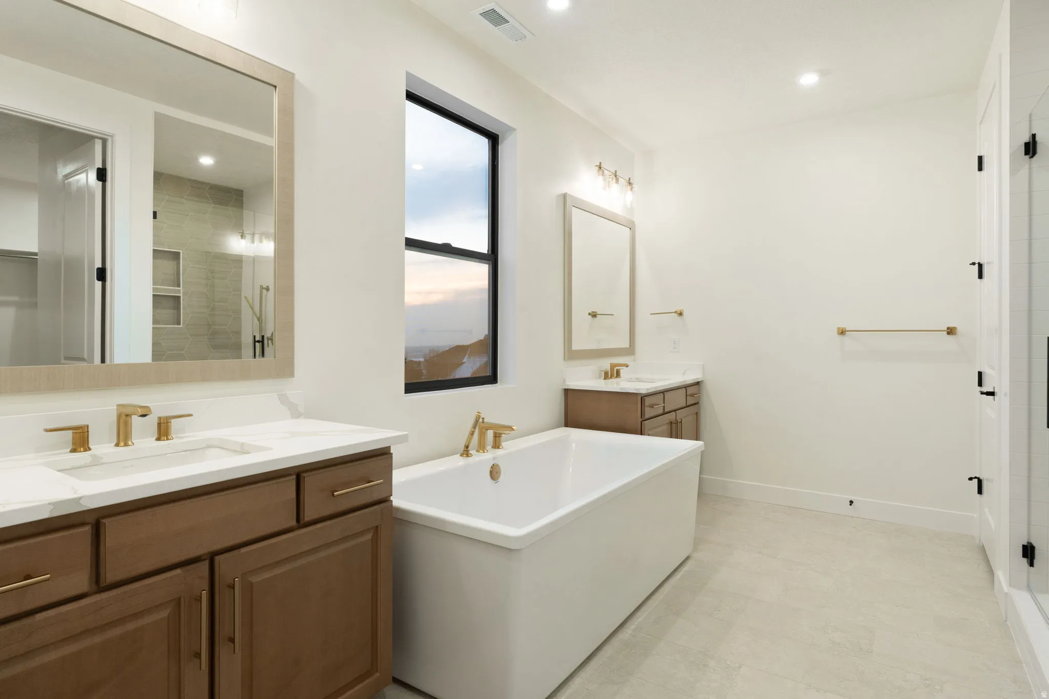 Bathroom featuring two vanities, a soaking tub, recessed lighting, light flooring, and a shower stall
