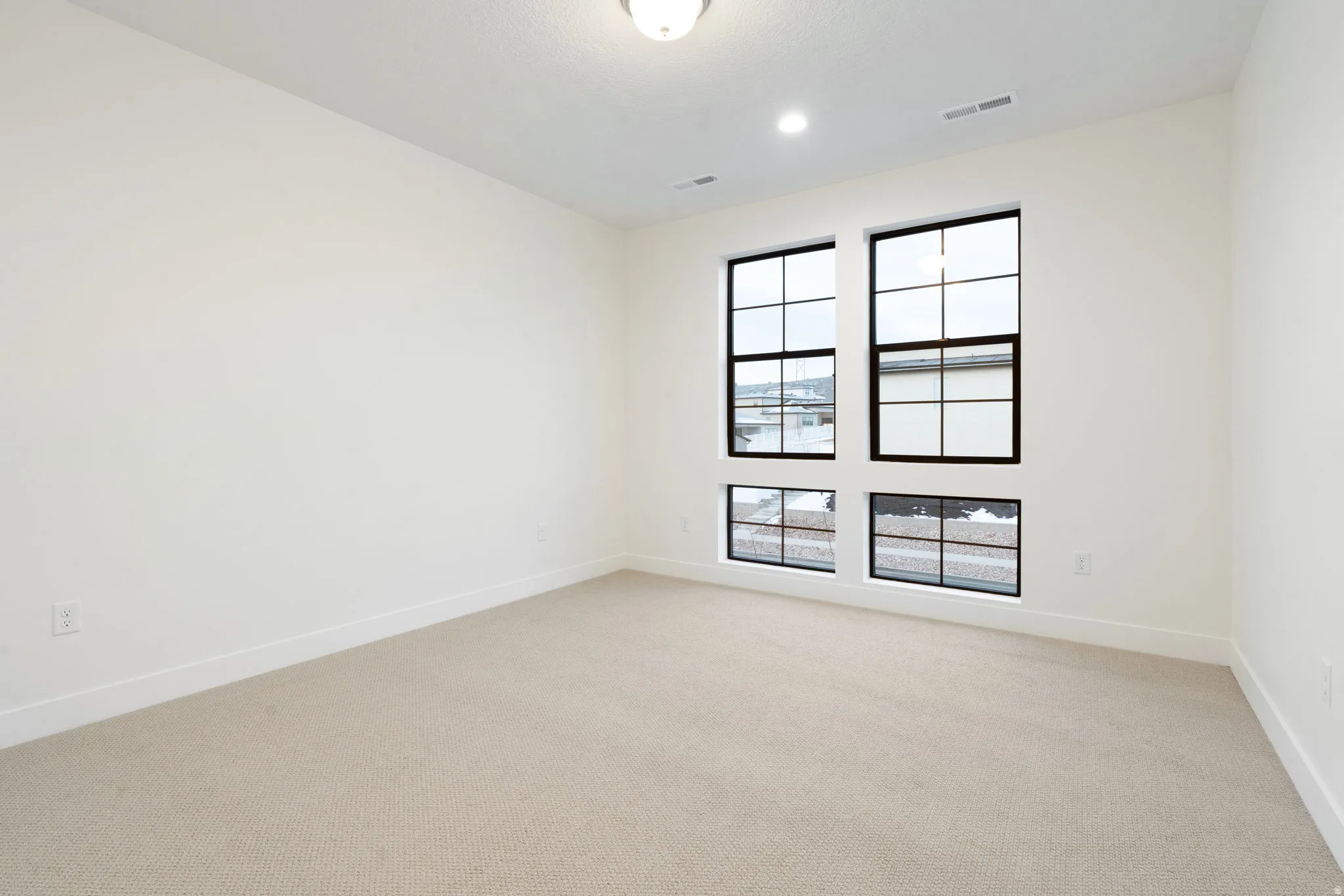 Empty room featuring light carpet and baseboards