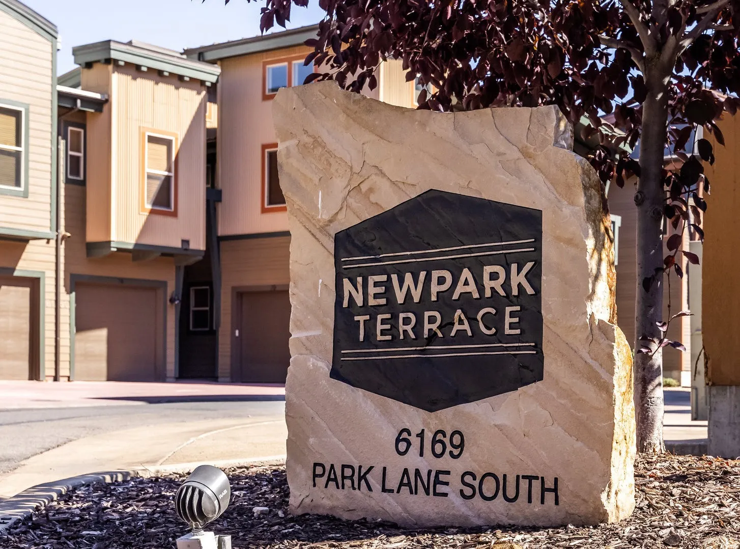 Community sign with an attached garage and concrete driveway