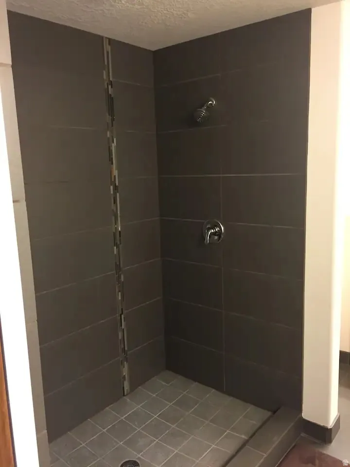 Full bath with a stall shower and a textured ceiling