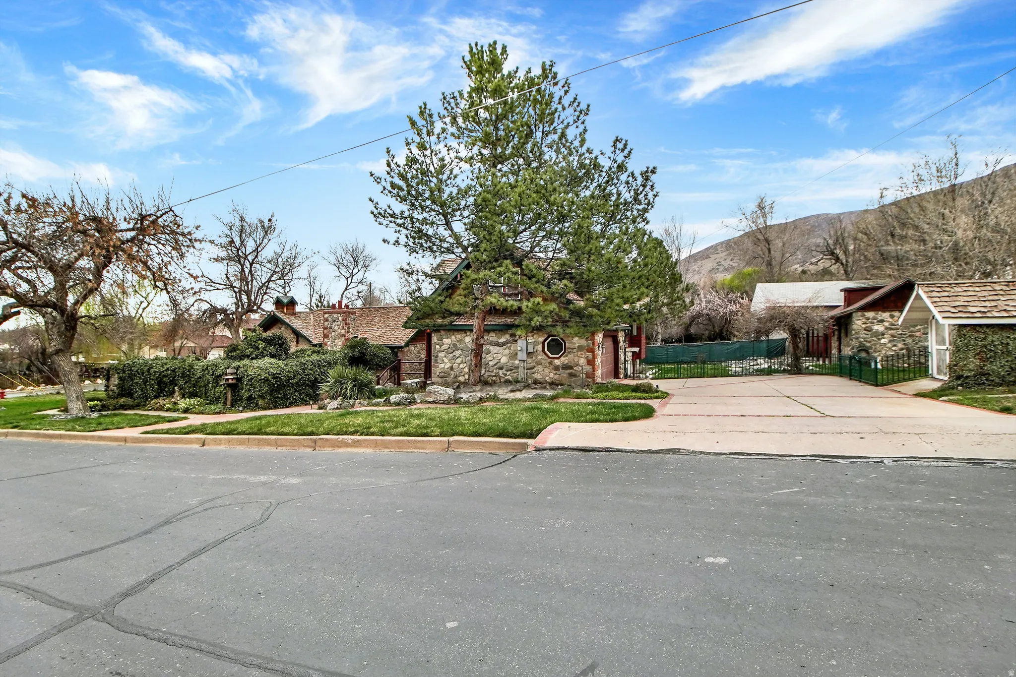 View of front of property with stone siding and driveway