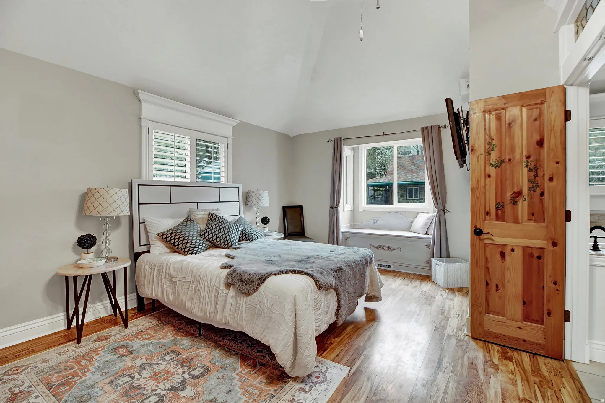 Bedroom featuring lofted ceiling, light wood-style flooring, and multiple windows