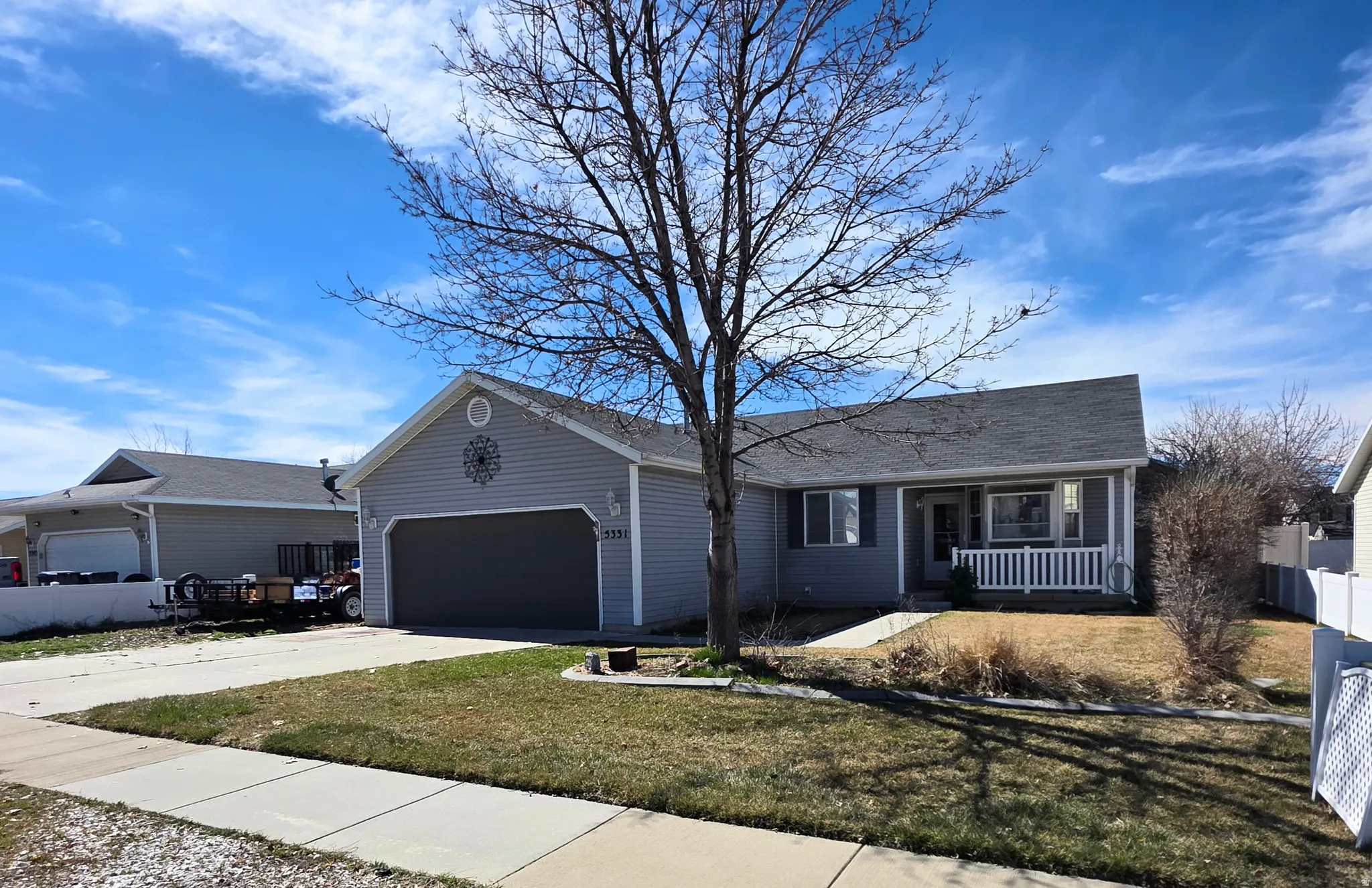 Single story home with covered porch, concrete driveway, and an attached garage