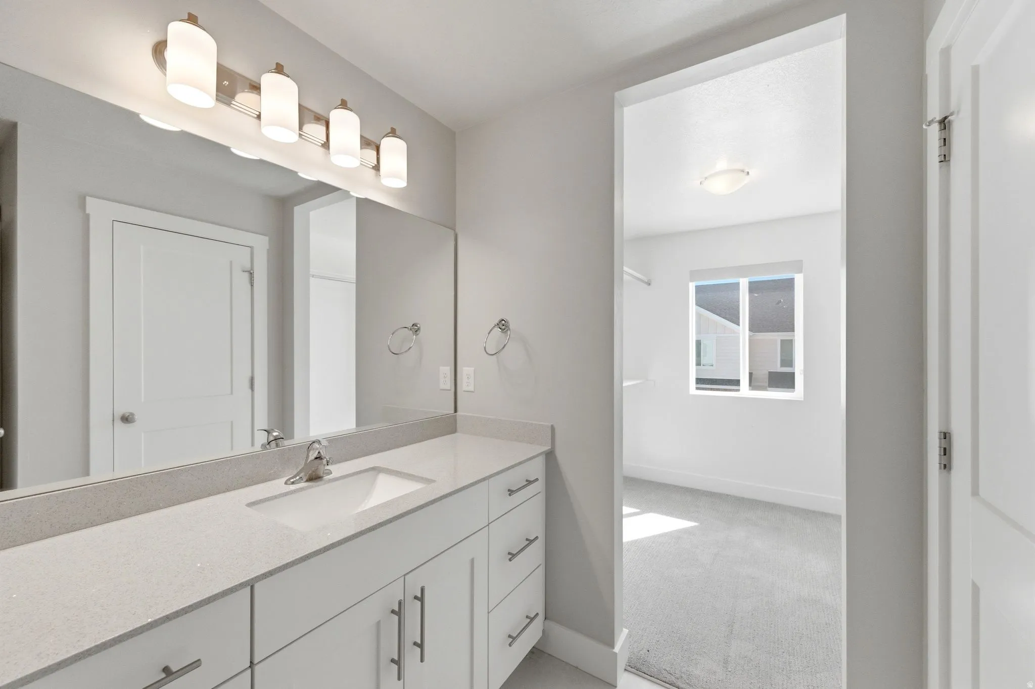 Bathroom featuring vanity and light colored carpet