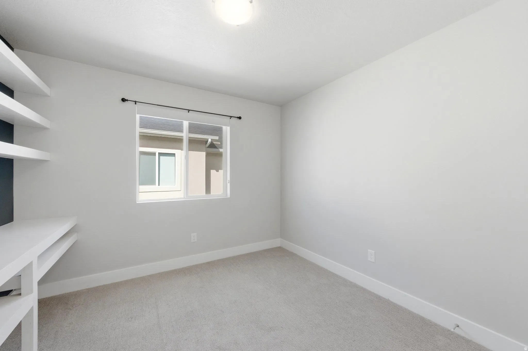 Empty room with baseboards and light colored carpet