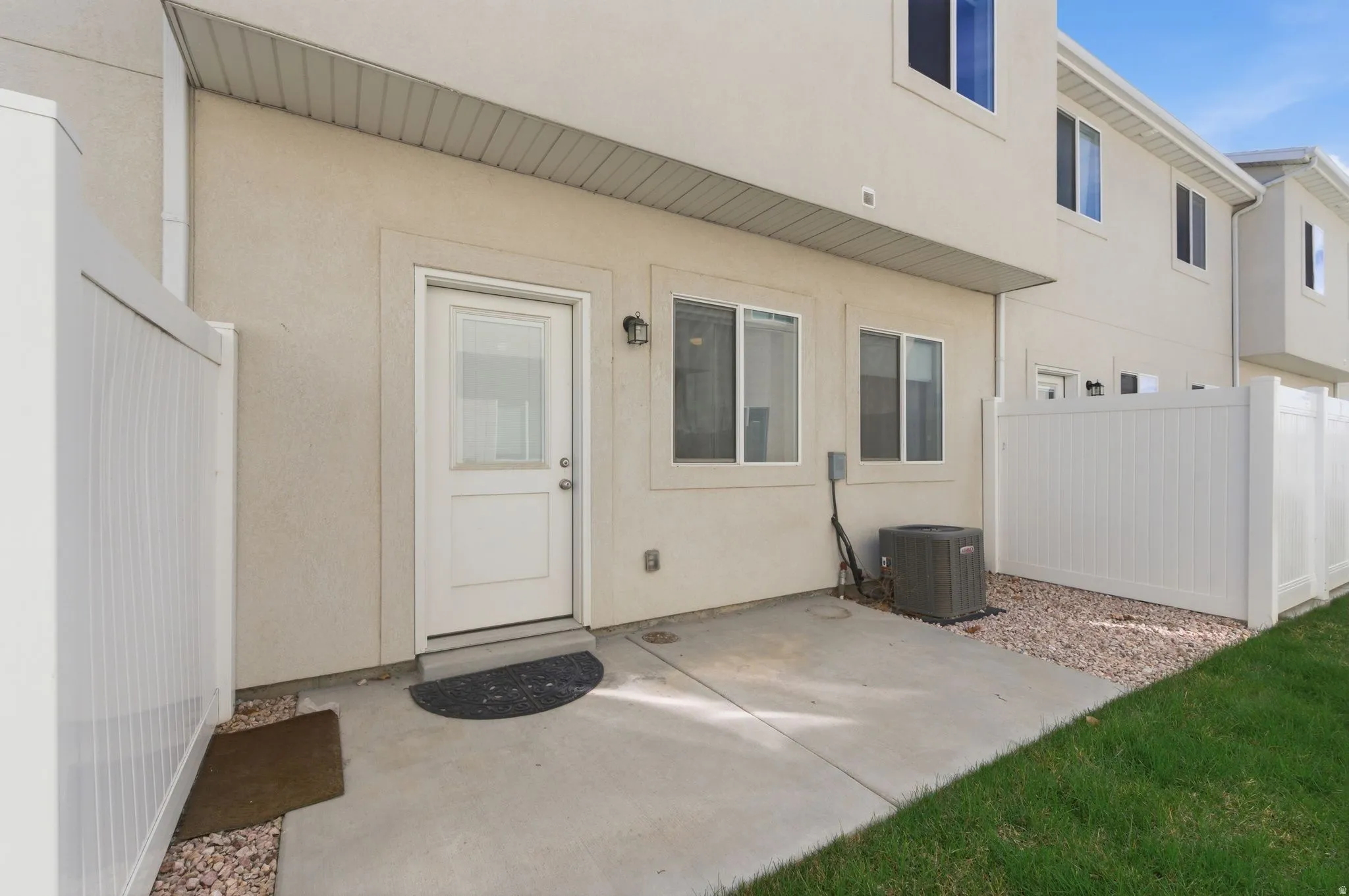 View of exterior entry featuring a patio area and stucco siding