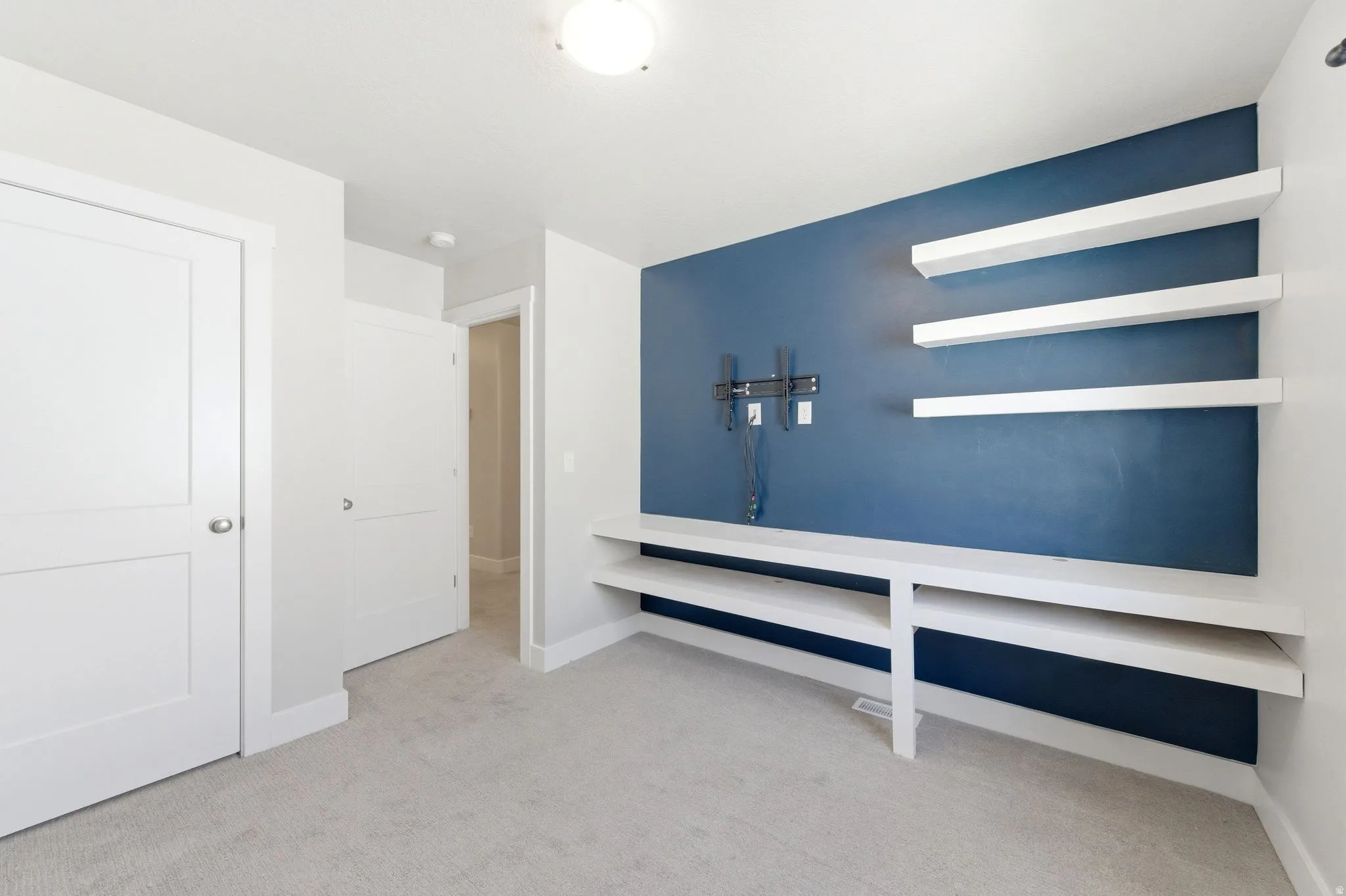 Interior space with light colored carpet and baseboards