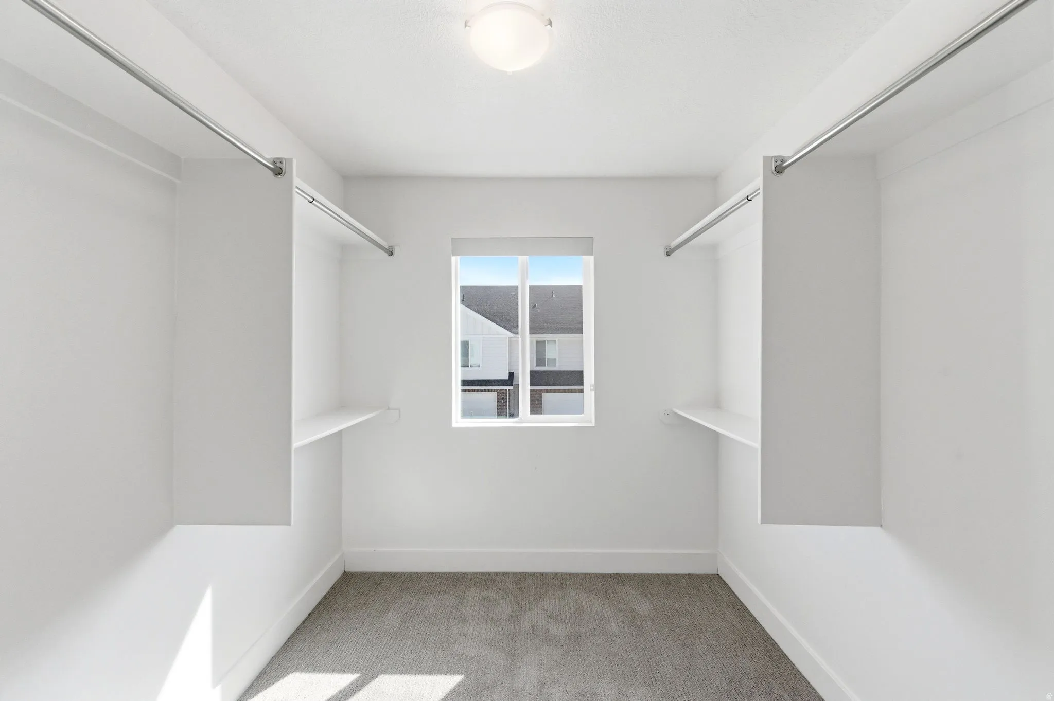 Walk in closet with light carpet