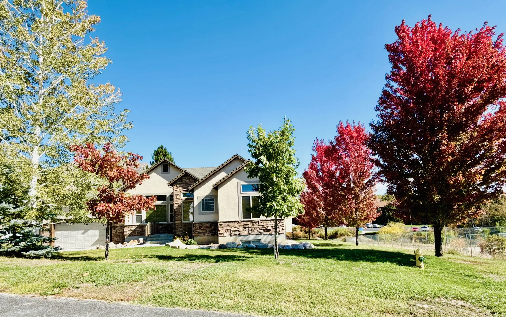 View of front of home featuring stone siding and stucco siding