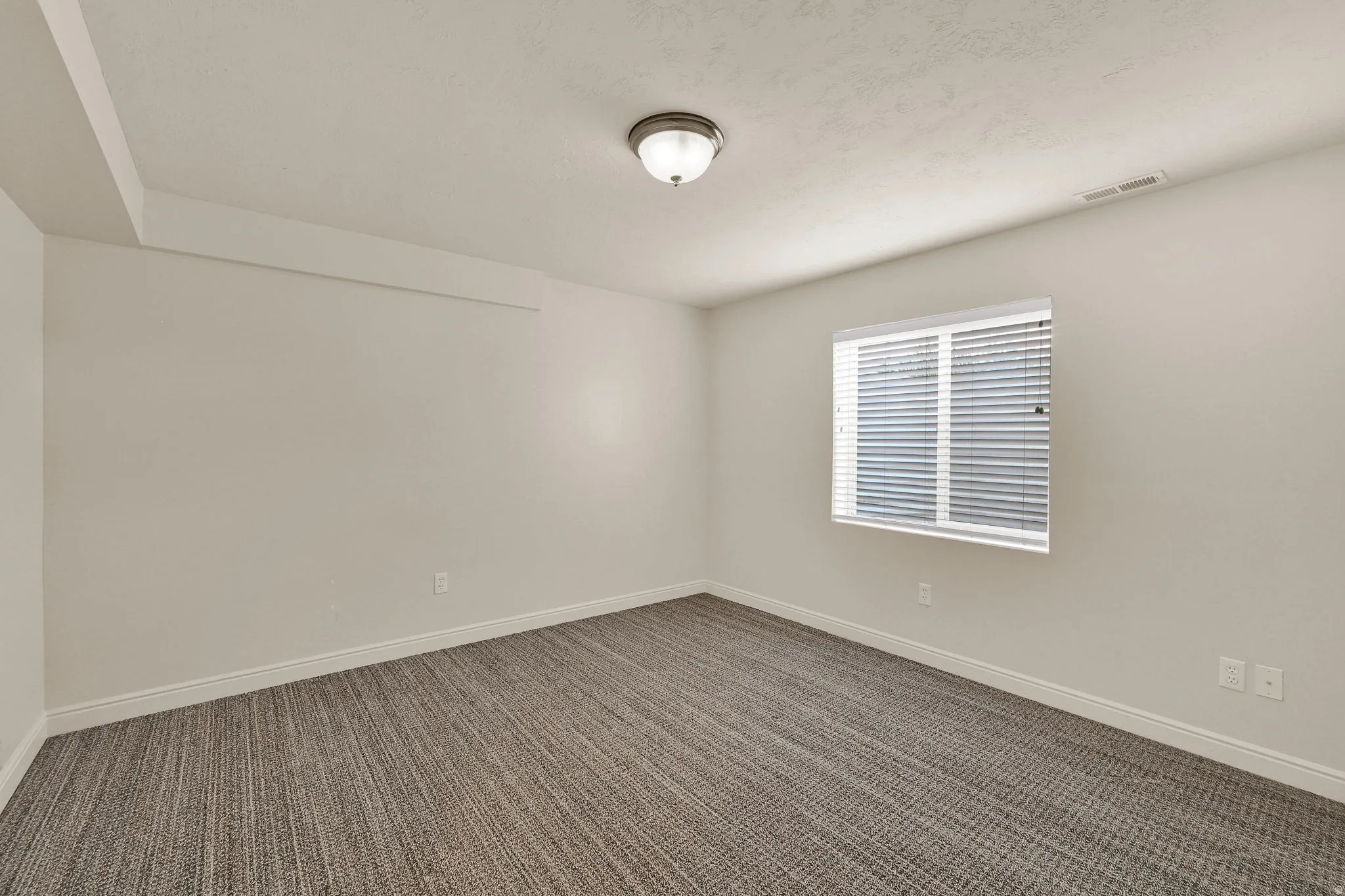Spare room with dark colored carpet and baseboards