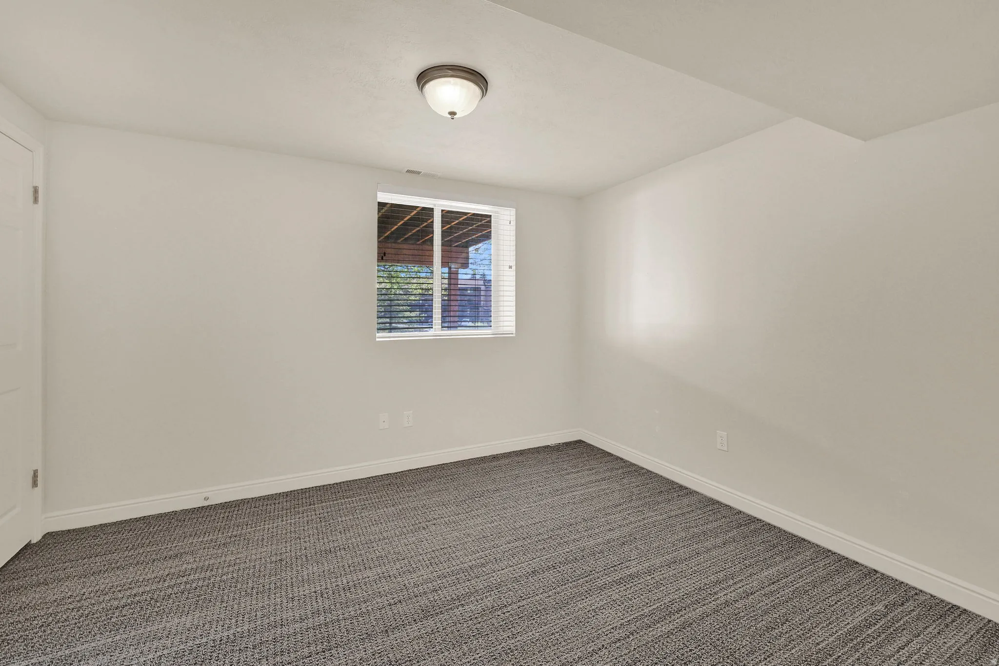 Spare room featuring dark colored carpet and baseboards