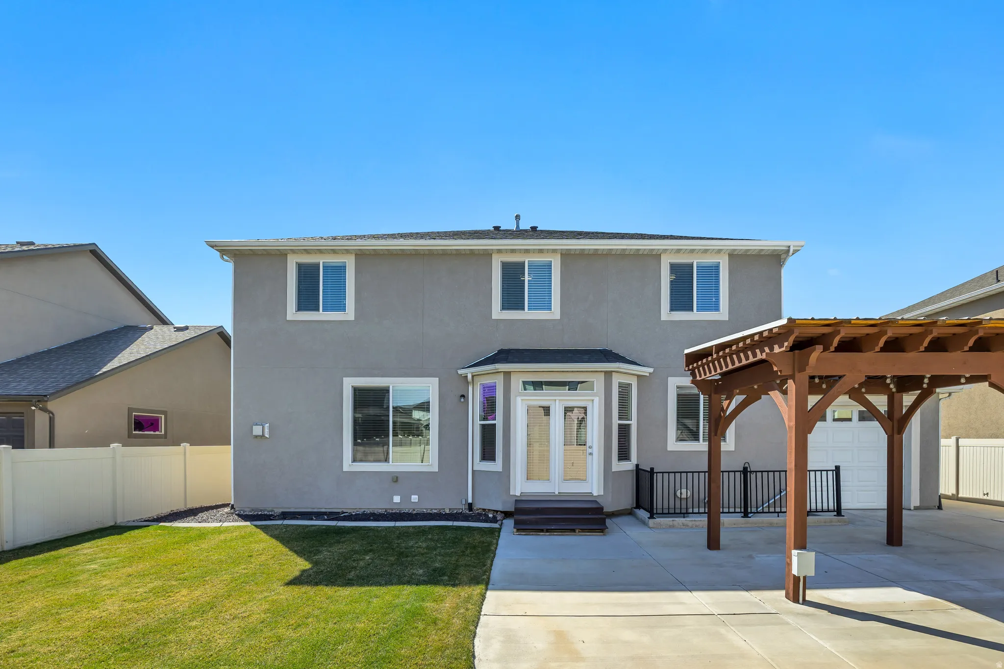Traditional-style home featuring stucco siding, french doors, driveway, and a patio