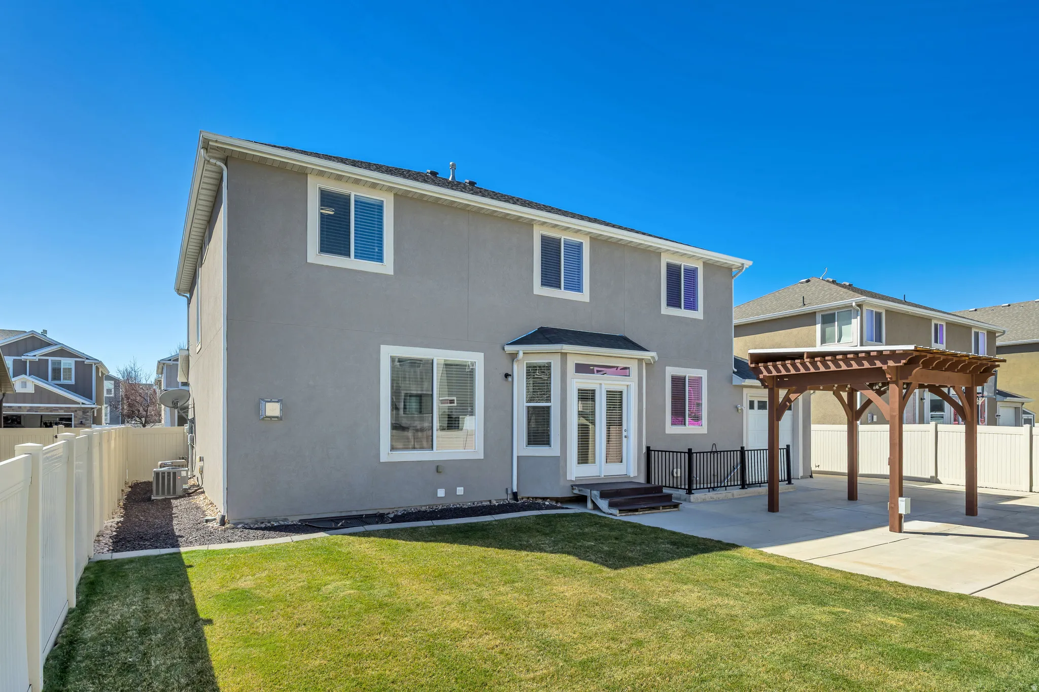 Rear view of property with stucco siding, a fenced backyard, a patio area, and a pergola