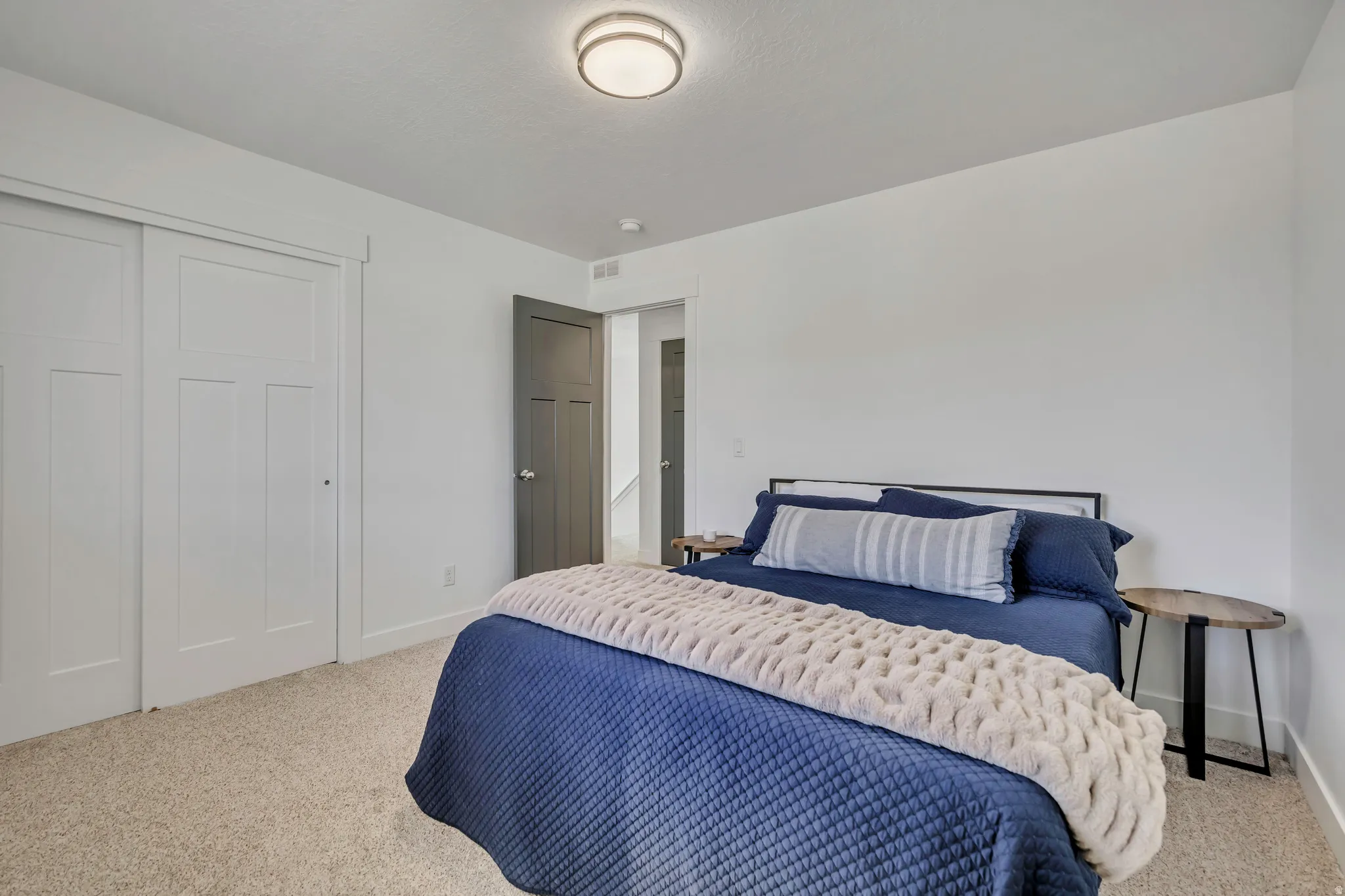 Bedroom featuring light carpet and a closet