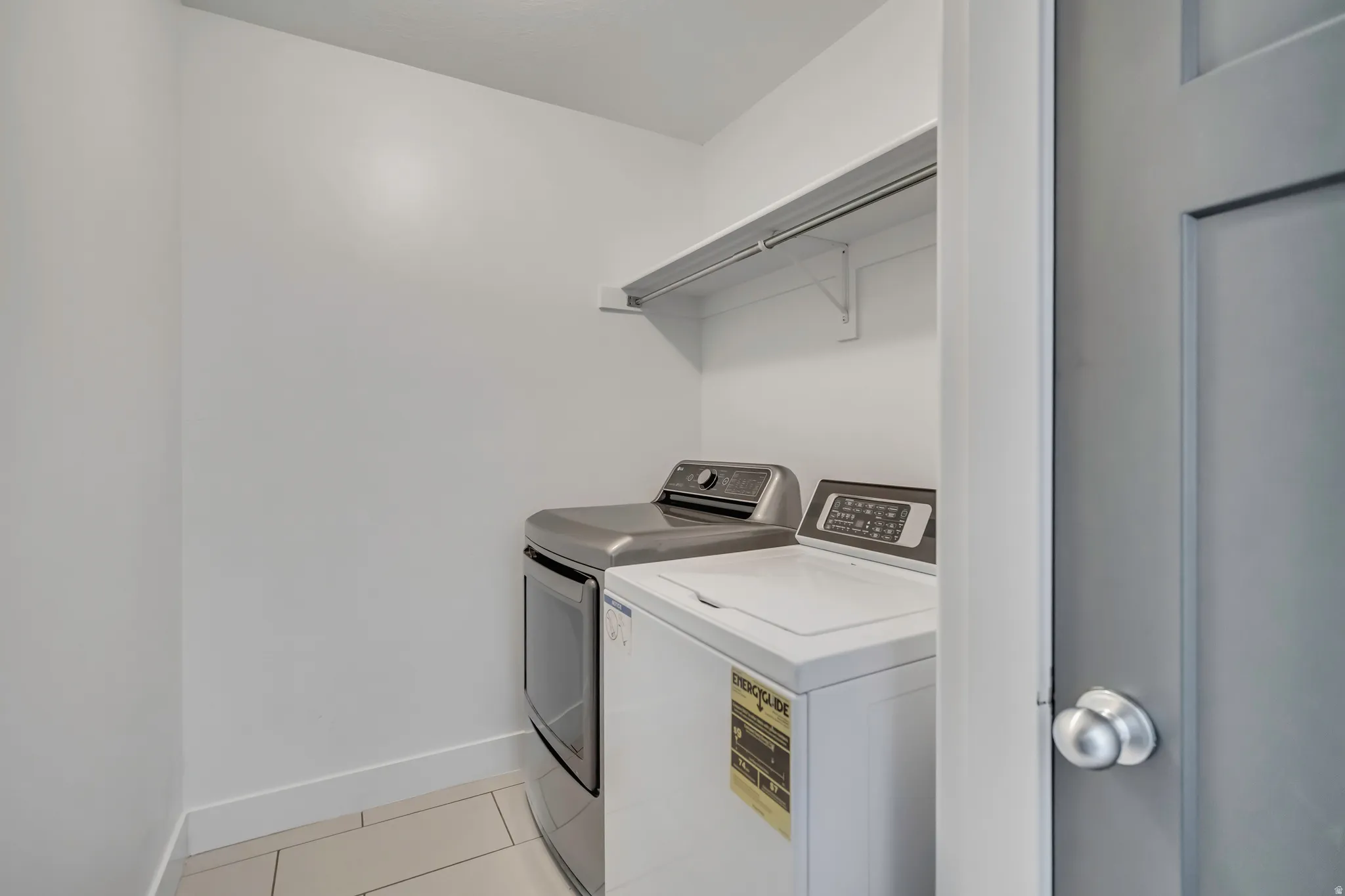 Laundry area with light tile patterned floors and independent washer and dryer