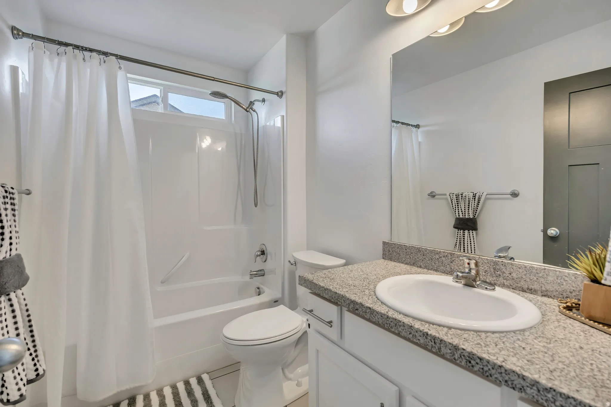 Bathroom with vanity and shower / bathtub combination with curtain