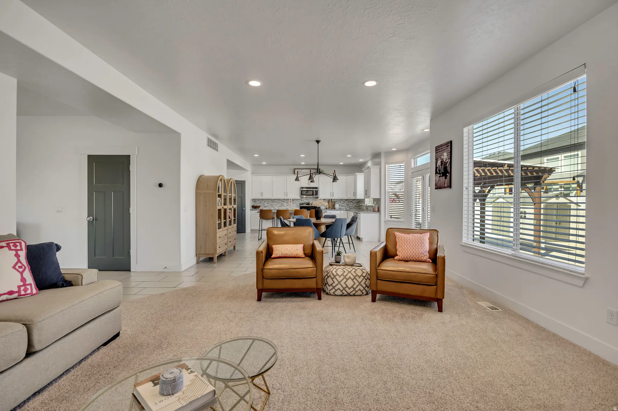 Living room with light colored carpet, recessed lighting, and light tile patterned flooring