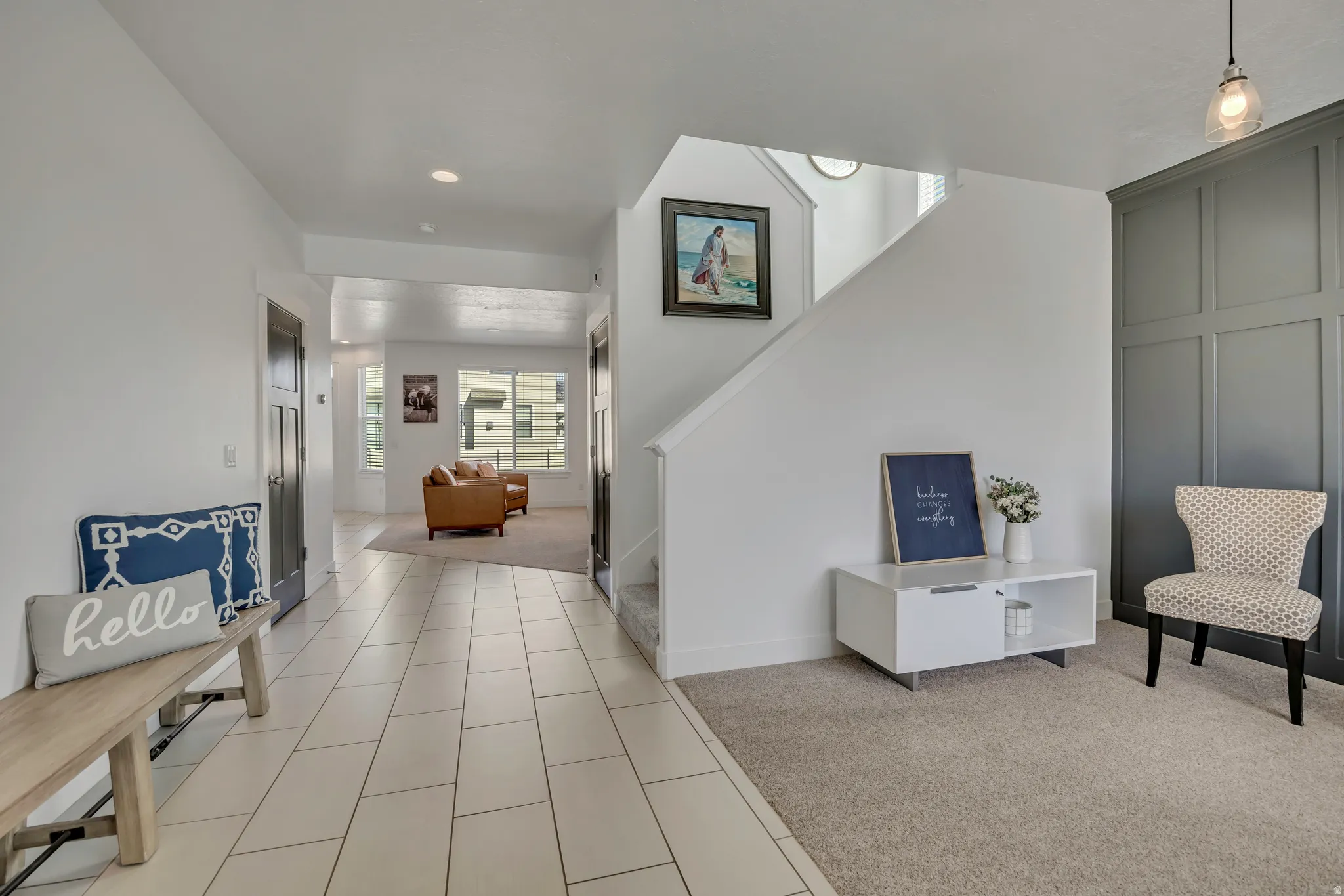 Foyer entrance featuring light colored carpet and light tile patterned floors