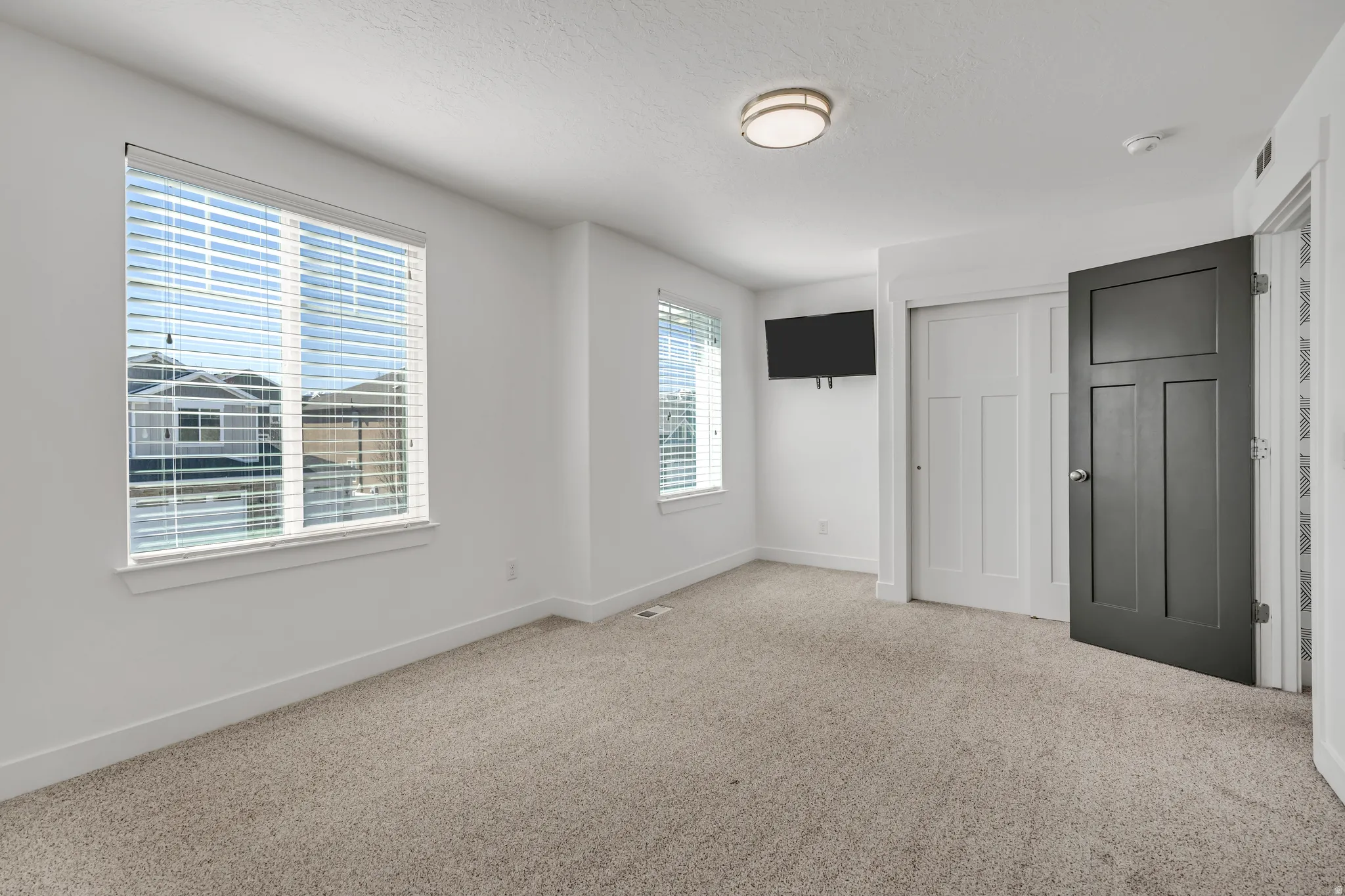 Unfurnished bedroom with a closet, light colored carpet, and a textured ceiling