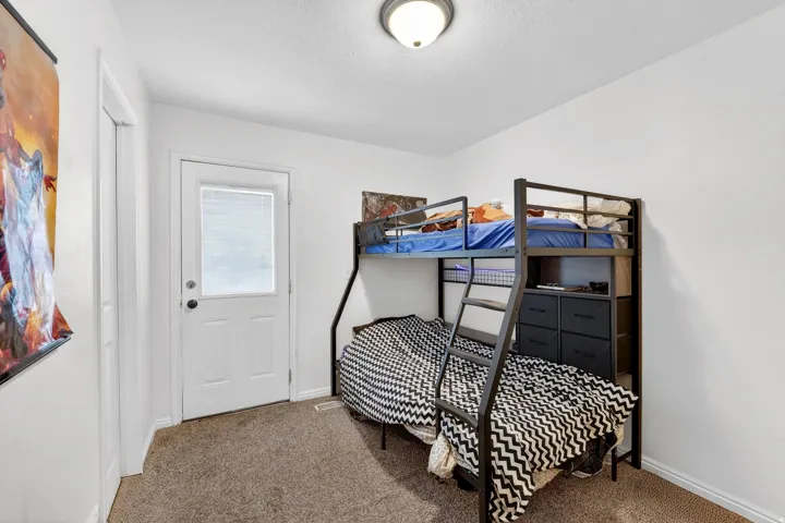 Bedroom featuring carpet and baseboards