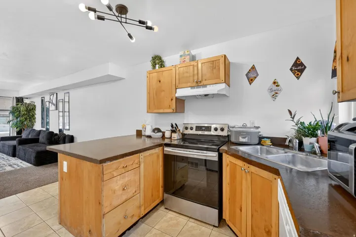 Kitchen with a peninsula, stainless steel appliances, open floor plan, and light tile patterned floors