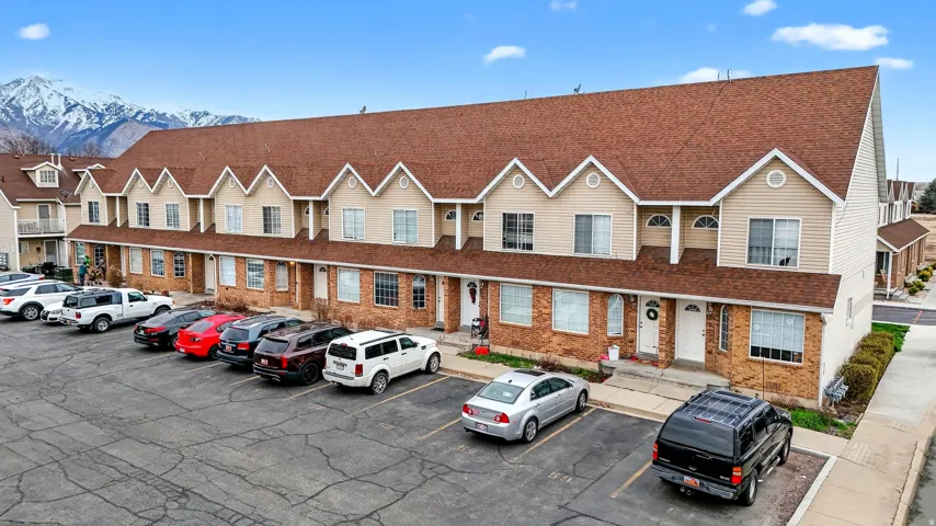 View of property with uncovered parking and a mountain view