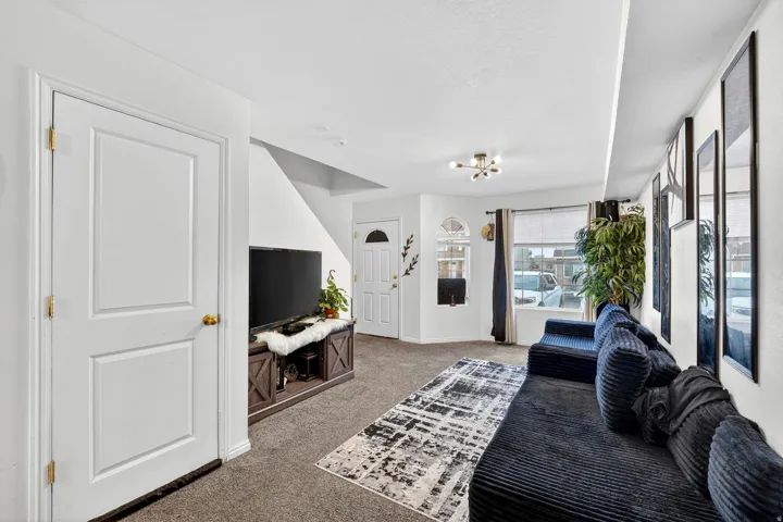 Living area with light colored carpet and a chandelier