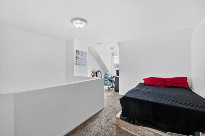 Bedroom featuring an office area and light colored carpet