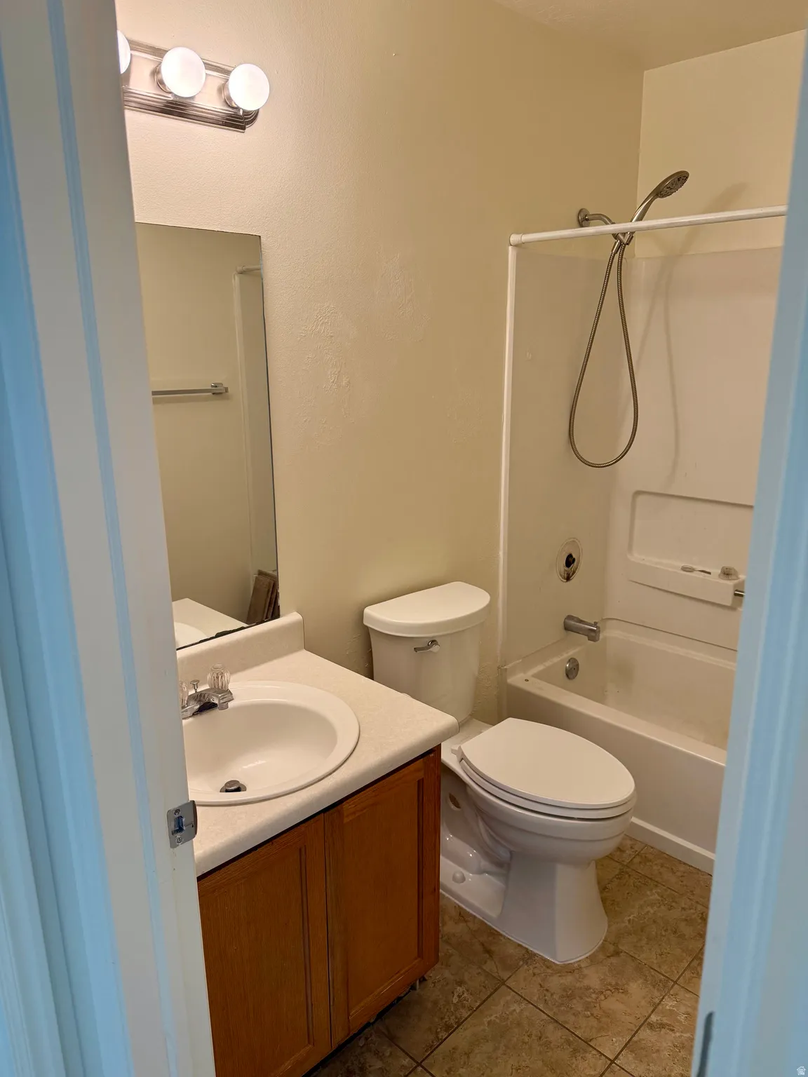 Bathroom featuring a single vanity with wood-finish cabinetry, a white countertop, and a classic white sink