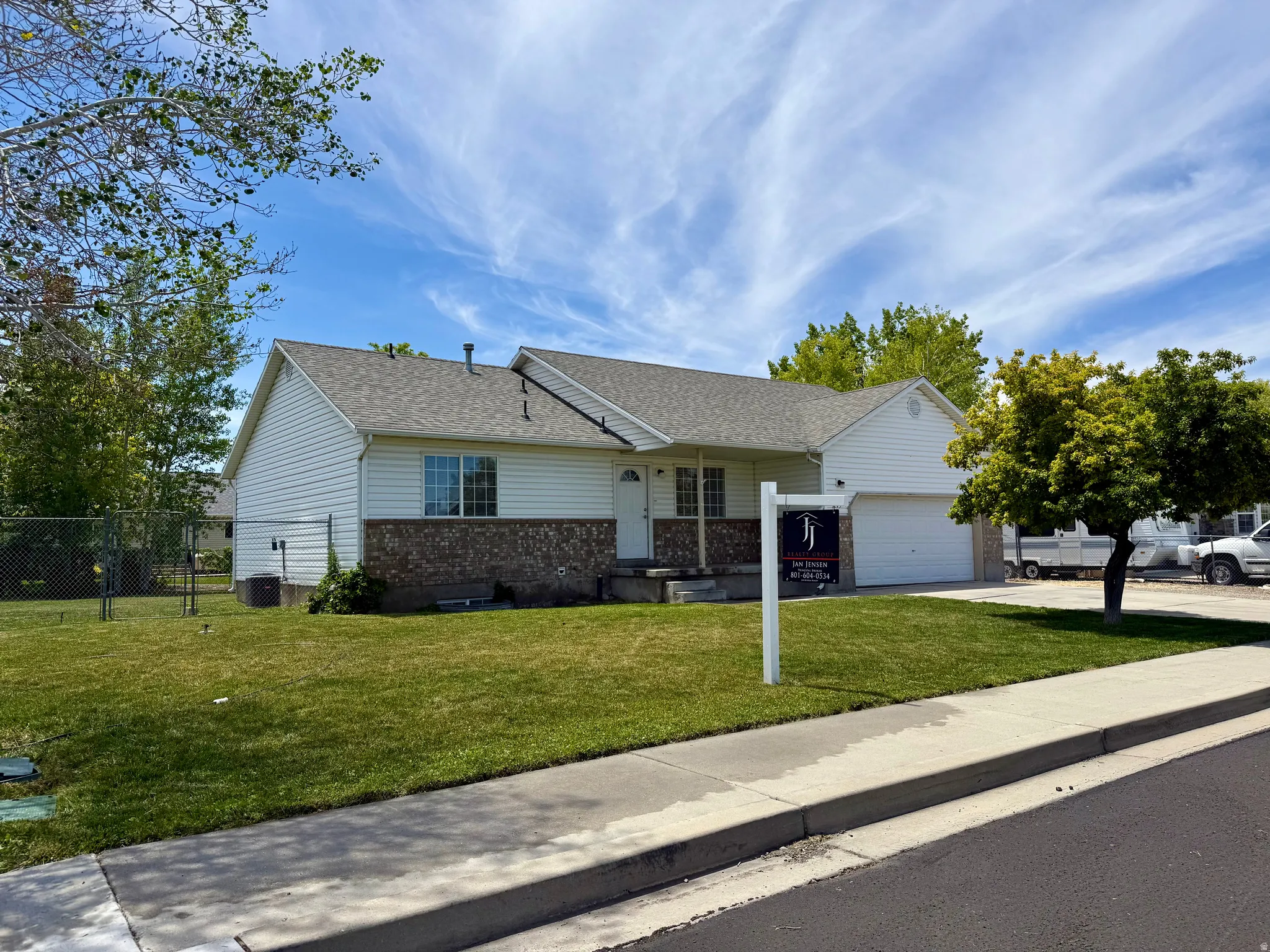Single-story residence featuring white vinyl siding and a stone-clad facade accent
