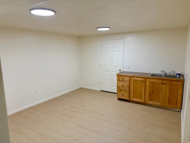 Open room featuring wood-finish flooring and cream-toned walls